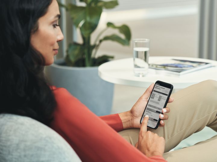 Woman is sitting on the couch and using a Kia service app
